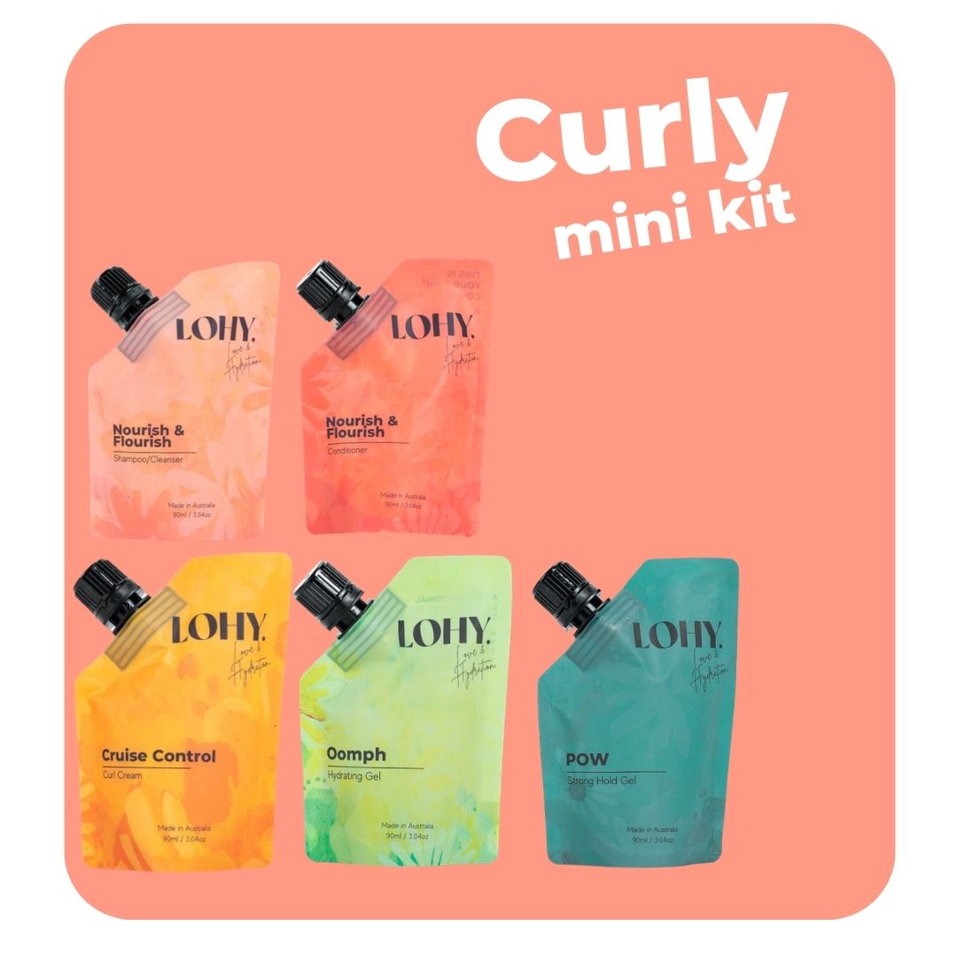 lohy. curly hair mini kit, which includes mini shampoo, mini conditioner, mini curl cream, mini hydrating gel and mini strong hold gel pouches on a pastel peach background