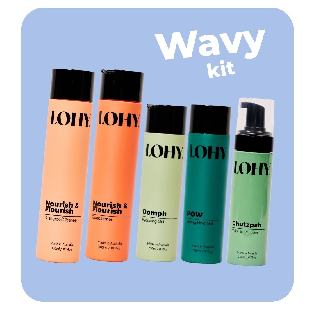 lohy. curly hair kit, which includes shampoo, conditioner, hydrating gel, strong hold gel and volumising foam bottles angled on a pastel blue background