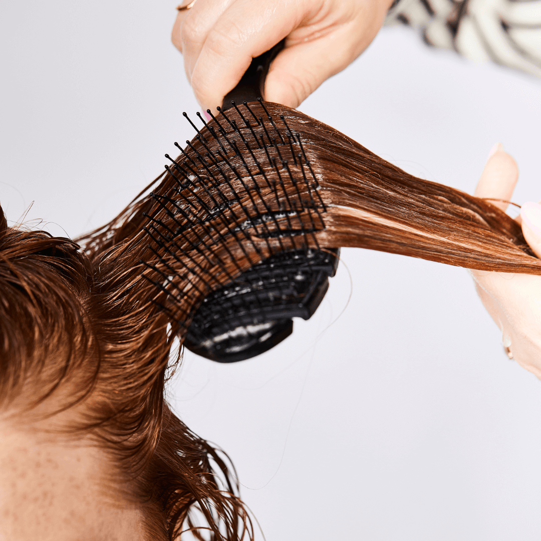 woman brushing, long, red, curly, wet hair