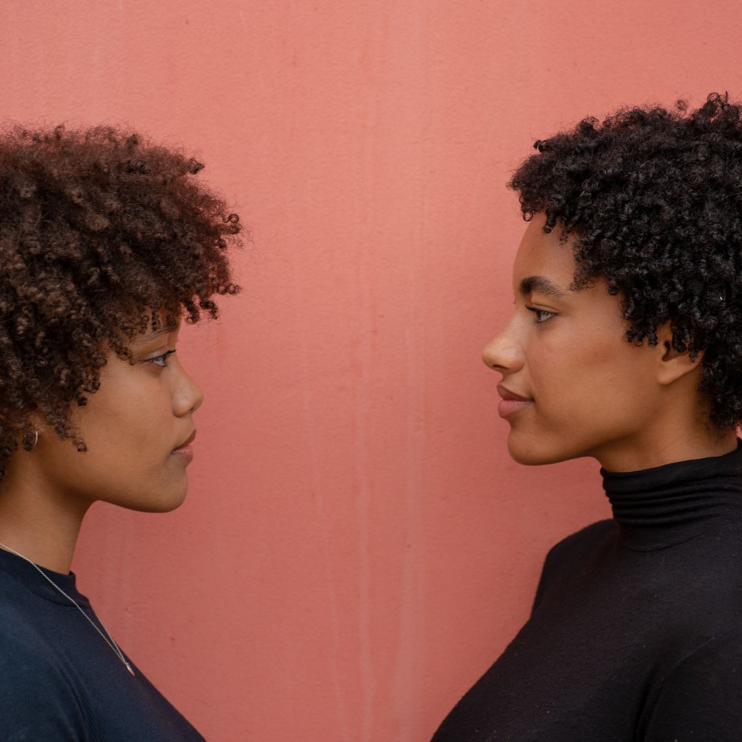 two women, black curly afro, brunette curly afro