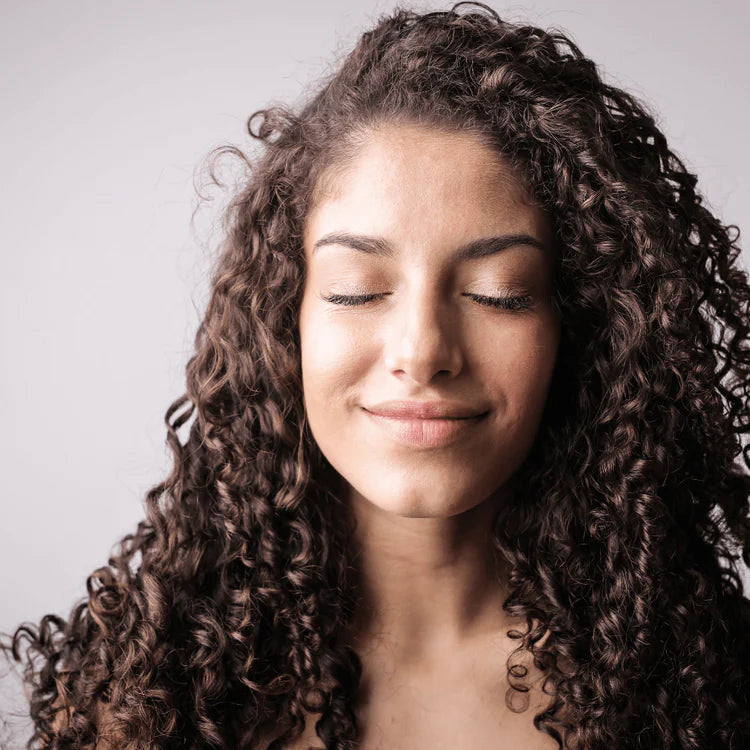 woman, long curly brunette hair, content