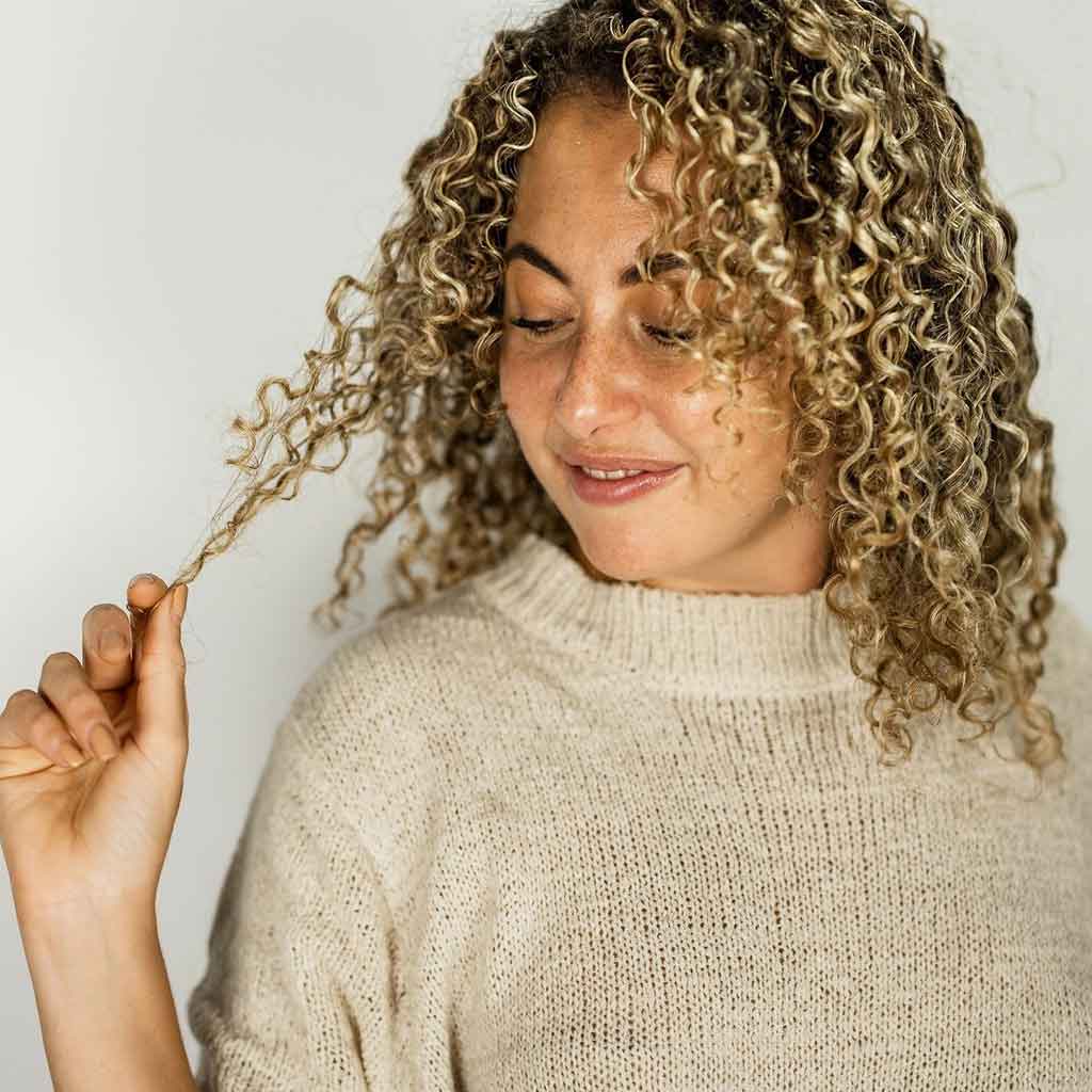 Curly girl playing with her hair